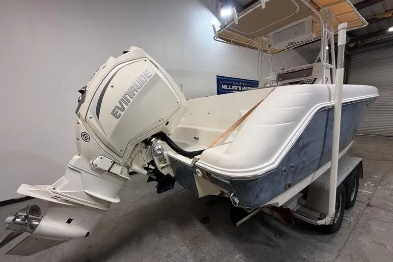 Slide: The Image of 2000 Pro-Line 23 Sport boat with Evinrude outboard motor on trailer in garage. - 4