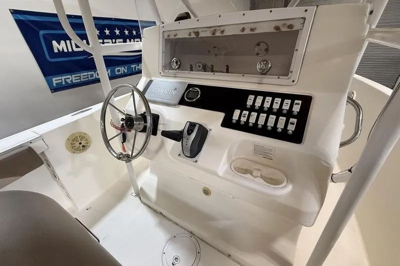 Slide: The Image of Control panel of a 2000 Pro-Line 23 Sport boat with steering wheel and switches. - 10