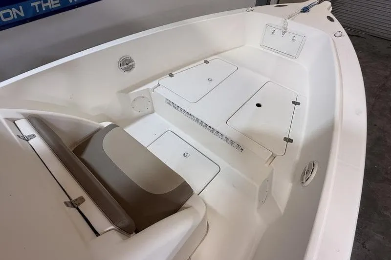 Slide: The Image of 2000 Pro-Line 23 Sport boat interior with white seating and storage compartments. - 18
