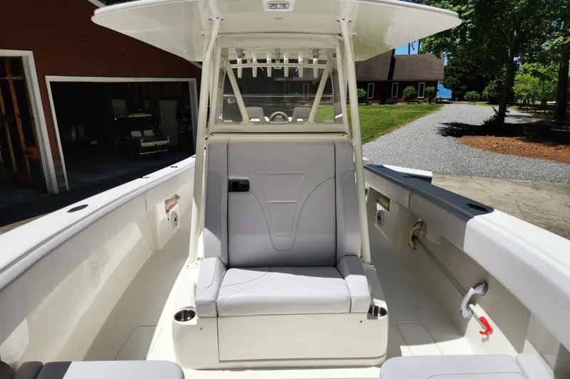 Slide: The Image of 2024 SeaVee 322Z boat interior with seating and console, parked near a house. - 4