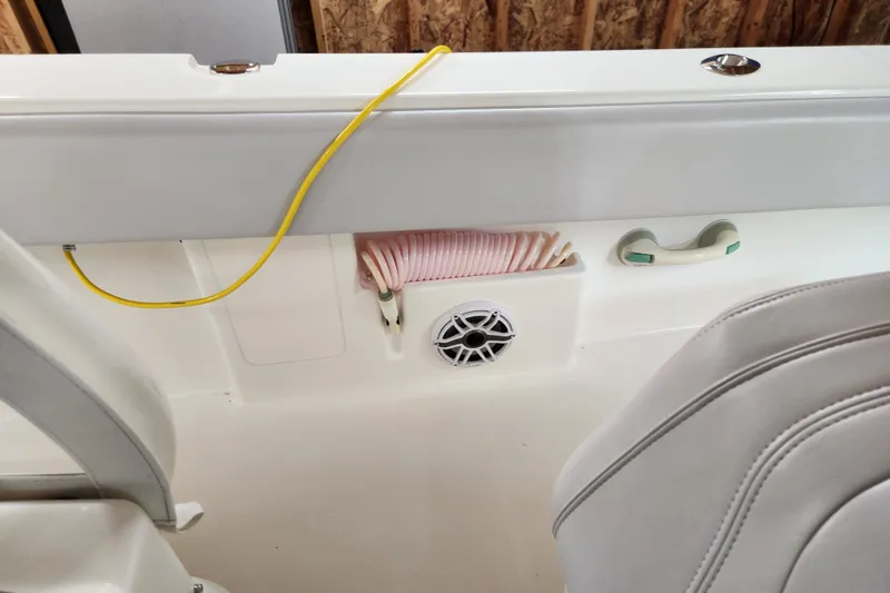 Slide: The Image of 2024 SeaVee 322Z boat interior with speaker, coiled hose, and seating detail. - 16