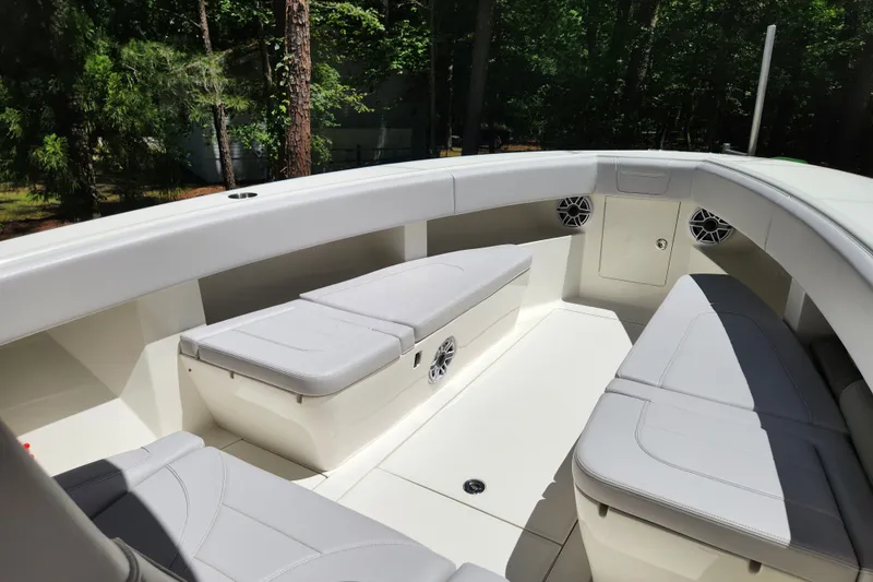 Slide: The Image of 2024 SeaVee 322Z boat interior with cushioned seating and speakers, surrounded by lush greenery. - 3