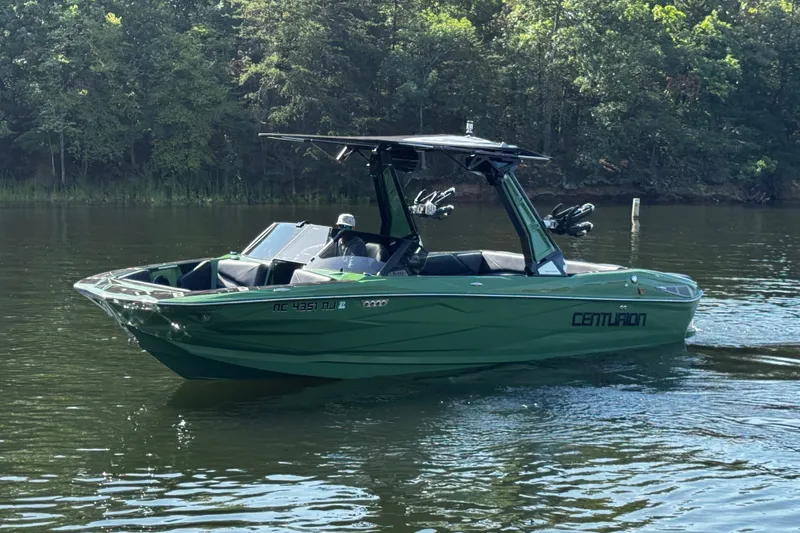 Slide: The Image of 2026 Centurion Nv243 boat on a calm lake with forest backdrop. - 13