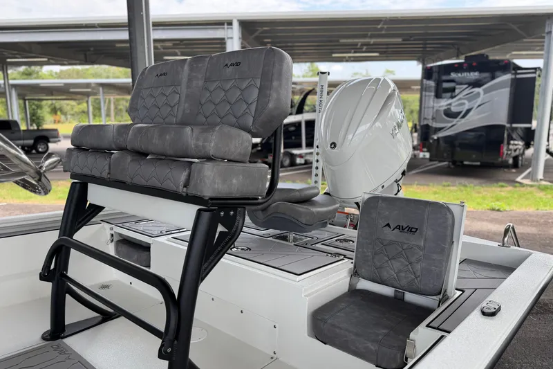 Slide: The Image of Avid 21 Mag 2027 boat interior with cushioned seating and motor, parked under a canopy. - 20