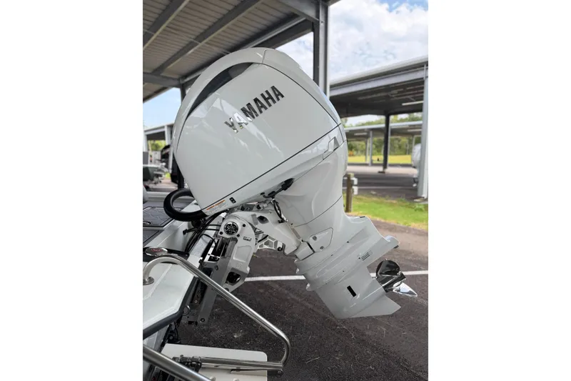 Slide: The Image of White Yamaha outboard motor on Avid 21 Mag boat, 2027 model, under a covered area. - 18