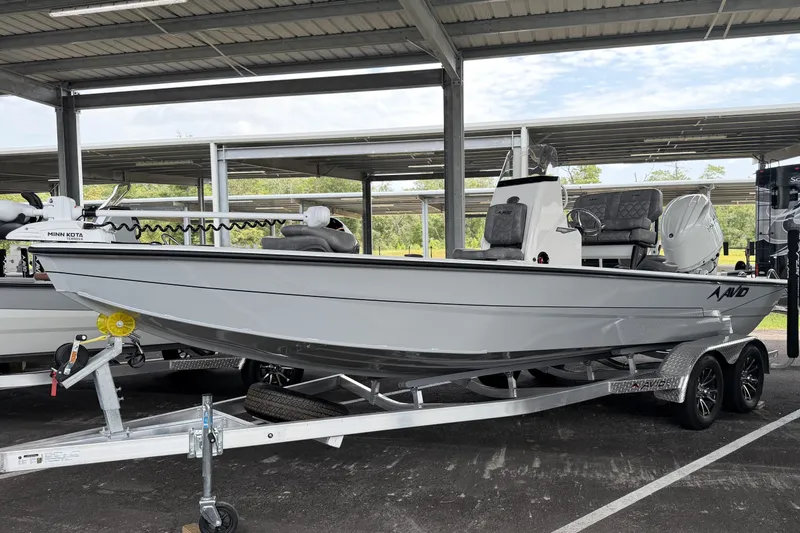 The Image of Avid 21 Mag 2027 boat on trailer under shelter, featuring Minn Kota trolling motor. - 0