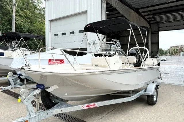 The Image of 2027 Boston Whaler 150 Montauk boat on trailer, parked outside a garage. - 0