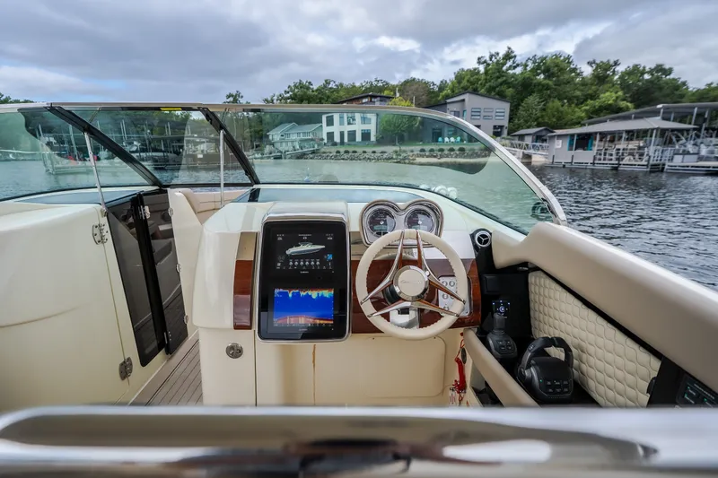 Slide: The Image of Interior view of 2027 Chris-Craft Launch 35 GT boat, featuring modern dashboard and steering wheel. - 50