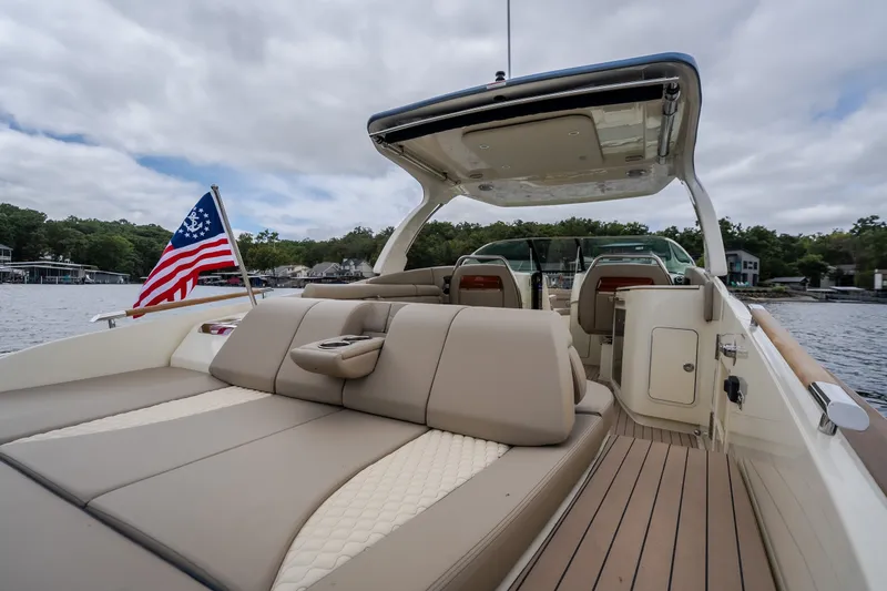 Slide: The Image of 2027 Chris-Craft Launch 35 GT boat interior with American flag, on a serene lake. - 20