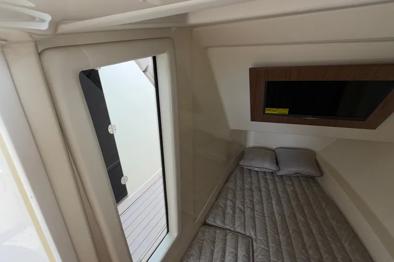 Slide: The Image of 2027 Chris-Craft Launch 35 GT cabin interior with bed, window, and mounted TV. - 50
