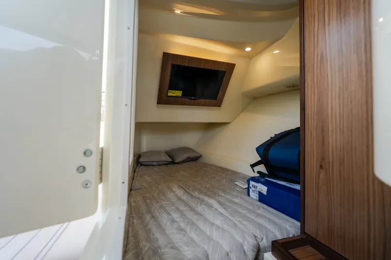 Slide: The Image of 2027 Chris-Craft Launch 35 GT cabin interior with bed, TV, and storage. - 68