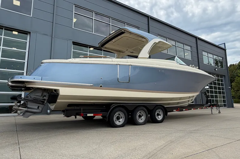 Slide: The Image of 2027 Chris-Craft Launch 35 GT boat on trailer, parked outside modern building. - 3