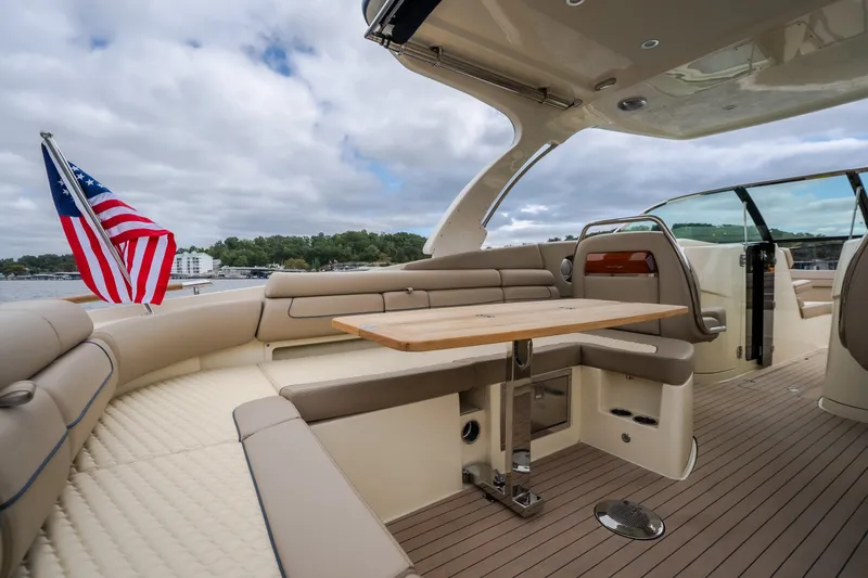 Slide: The Image of Luxurious 2027 Chris-Craft Launch 35 GT boat interior with seating and table, docked by a lake. - 42