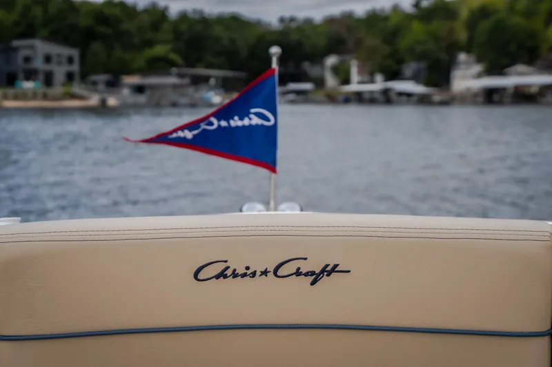 Slide: The Image of 2027 Chris-Craft Launch 35 GT boat with logo and flag on a lake. - 73