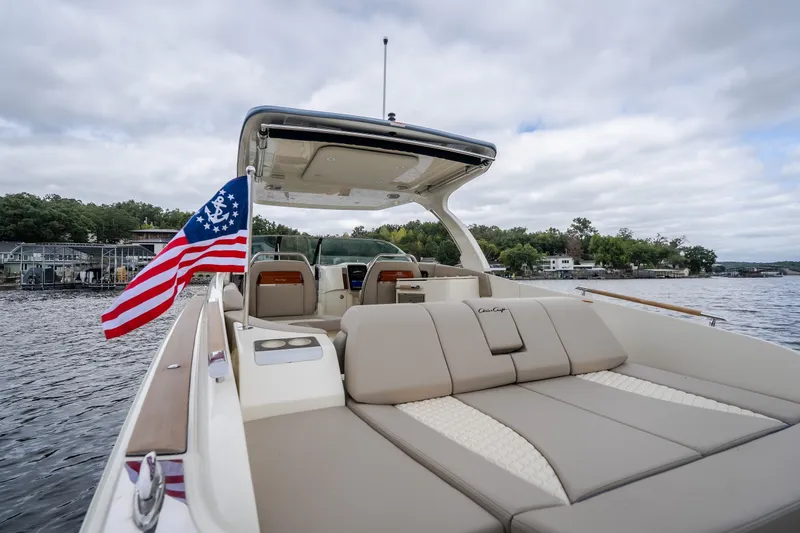 Slide: The Image of 2027 Chris-Craft Launch 35 GT boat with American flag on a lake. - 16