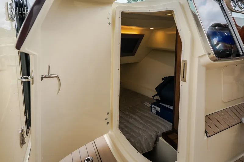 Slide: The Image of 2027 Chris-Craft Launch 35 GT cabin interior with open door, showcasing cozy sleeping area. - 67