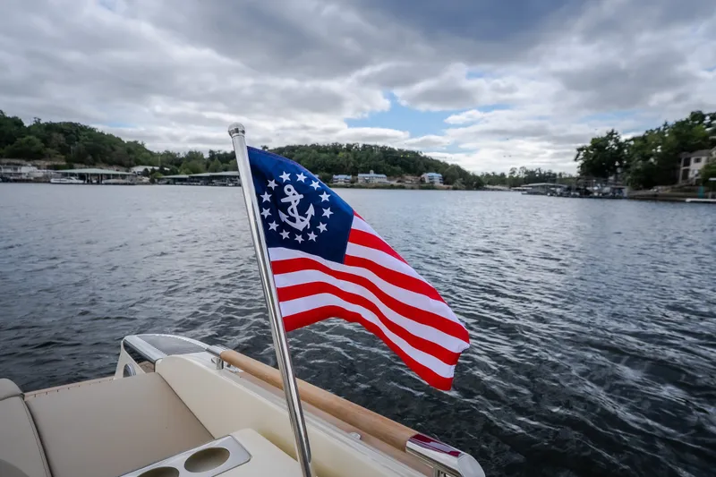 Slide: The Image of 2027 Chris-Craft Launch 35 GT on water, featuring nautical flag and scenic backdrop. - 28