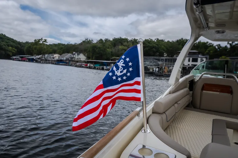 Slide: The Image of 2027 Chris-Craft Launch 35 GT boat with nautical flag on a serene lake. - 15
