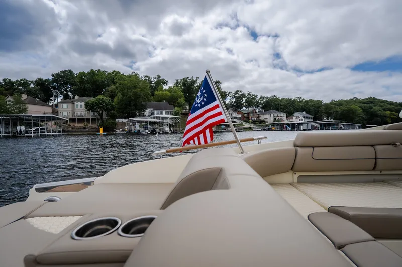 Slide: The Image of 2027 Chris-Craft Launch 35 GT boat with American flag on a scenic lake. - 22
