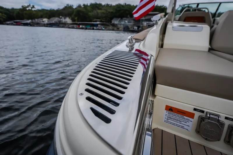 Slide: The Image of 2027 Chris-Craft Launch 35 GT boat detail with American flag on a lake. - 30