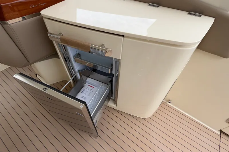 Slide: The Image of 2027 Chris-Craft Launch 35 GT boat interior with open refrigerator on deck. - 36