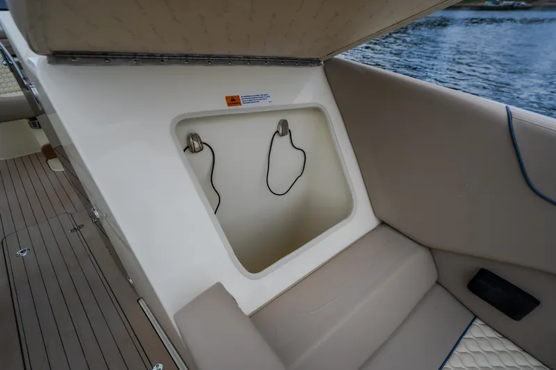 Slide: The Image of 2027 Chris-Craft Launch 35 GT boat storage compartment with beige seating and water view. - 78