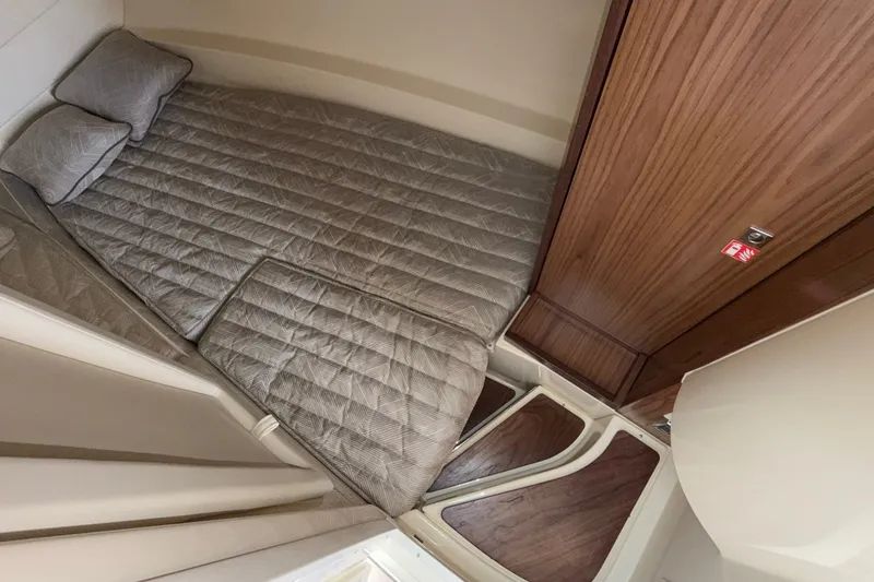 Slide: The Image of 2027 Chris-Craft Launch 35 GT cabin interior with cozy bed and wooden accents. - 48
