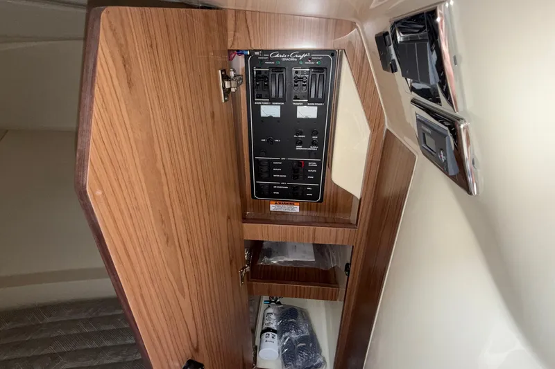 Slide: The Image of Electrical panel inside 2027 Chris-Craft Launch 35 GT boat, featuring wood finish and control switches. - 49