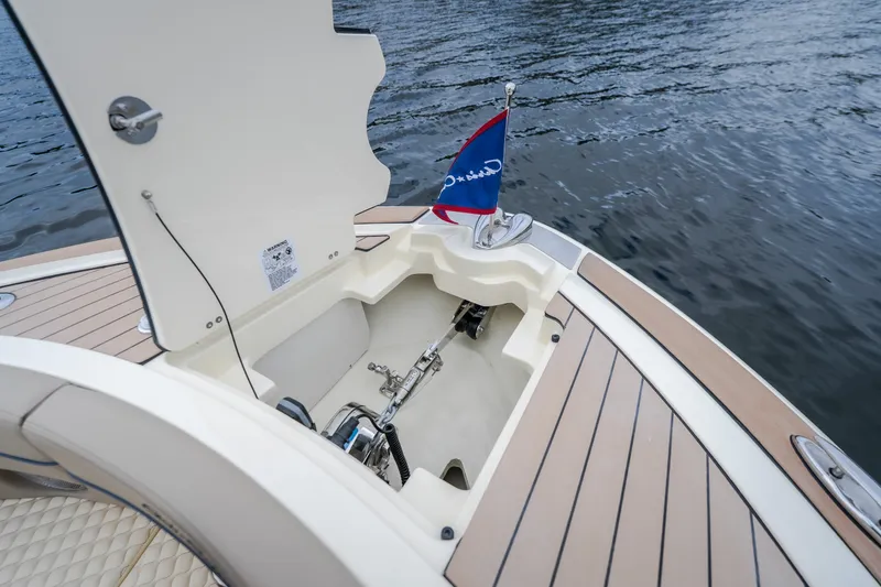 Slide: The Image of 2027 Chris-Craft Launch 35 GT boat anchor compartment with flag, docked on water. - 76