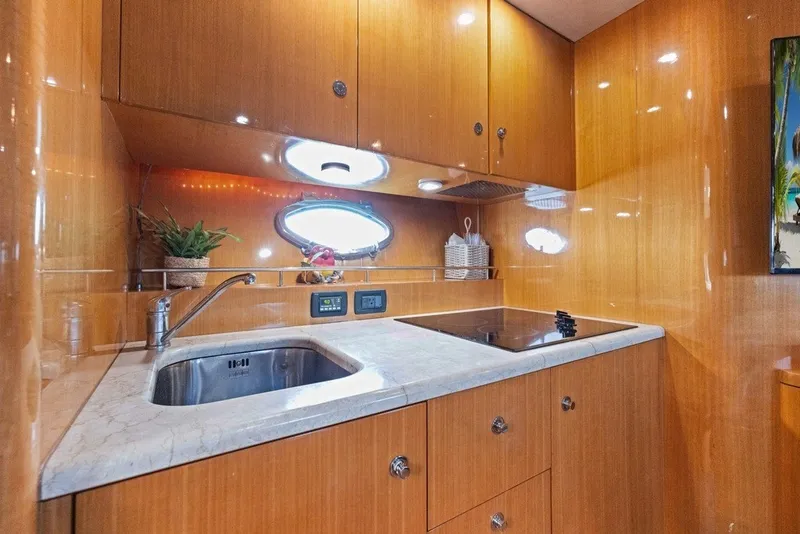 Slide: The Image of Luxurious 2005 Uniesse 54 Sport yacht kitchen with sleek wood cabinetry and modern amenities. - 10