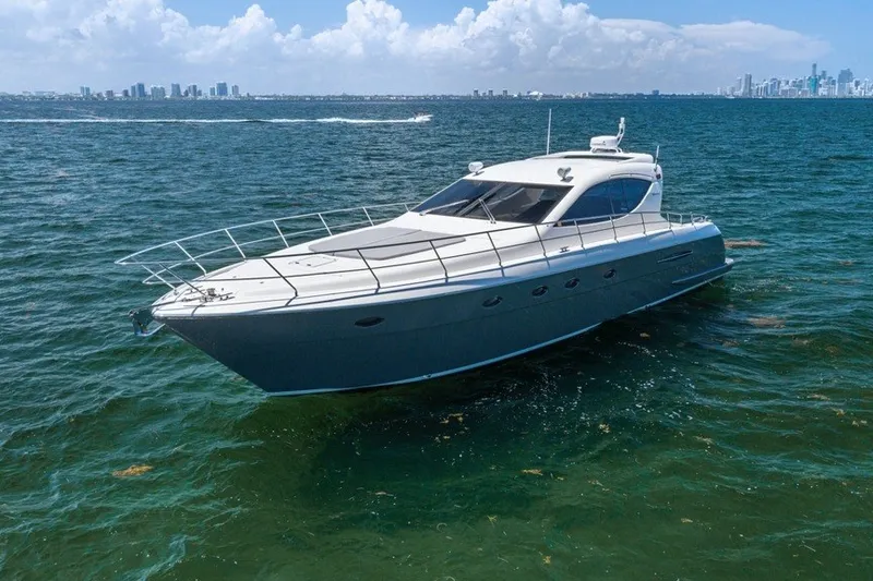 Slide: The Image of 2005 Uniesse 54 Sport yacht cruising on open water with city skyline in background. - 1