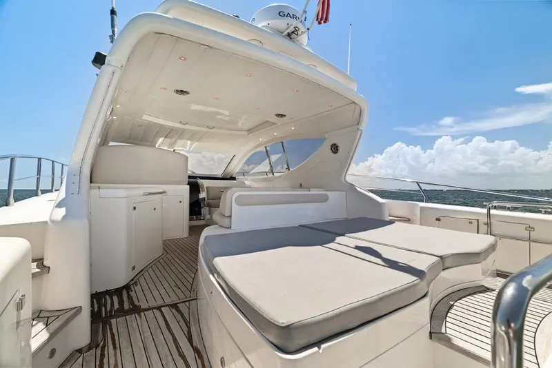 Slide: The Image of 2005 Uniesse 54 Sport yacht with spacious deck and luxurious seating under clear skies. - 25