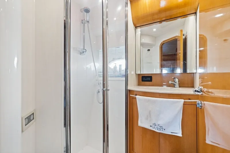 Slide: The Image of Luxurious bathroom in a 2005 Uniesse 54 Sport yacht, featuring a sleek shower and vanity. - 18