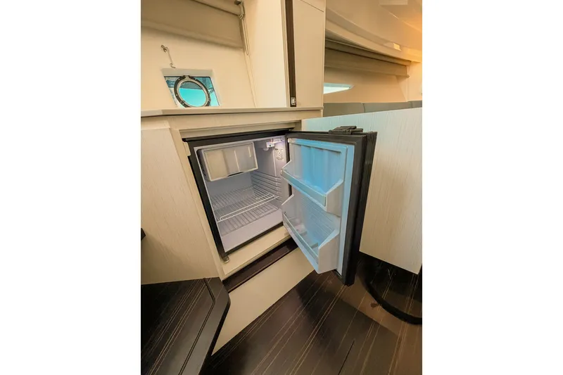 Slide: The Image of Compact refrigerator in 2024 FIM 34 Regina yacht interior, open door showing shelves. - 21