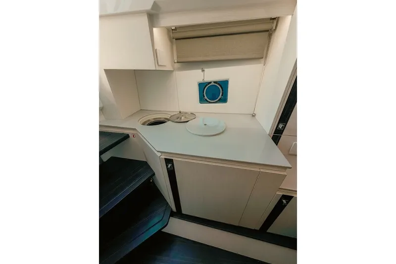 Slide: The Image of The interior view shows a compact kitchen with a sink and storage space. - 22