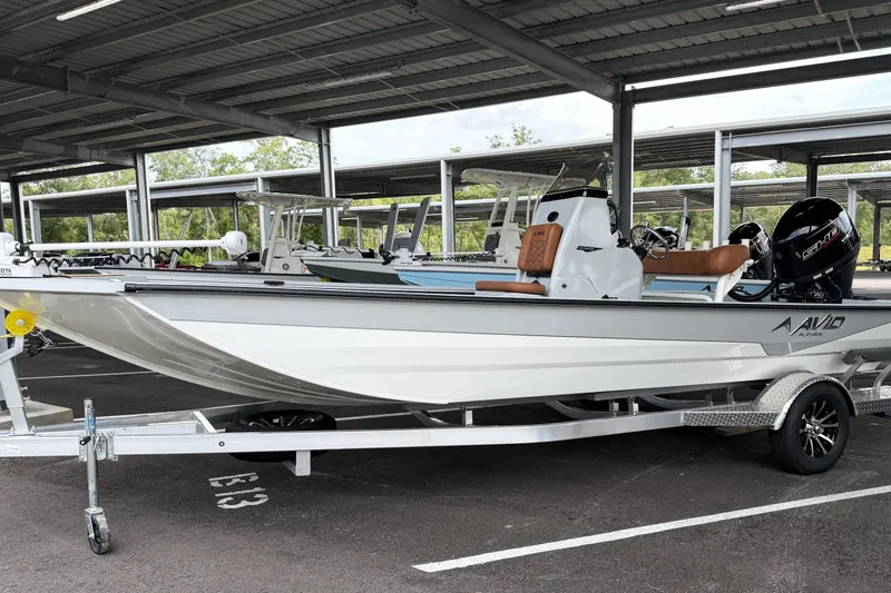 Slide: The Image of Avid 207 Recon 2027 boat on trailer in covered parking area. - 1