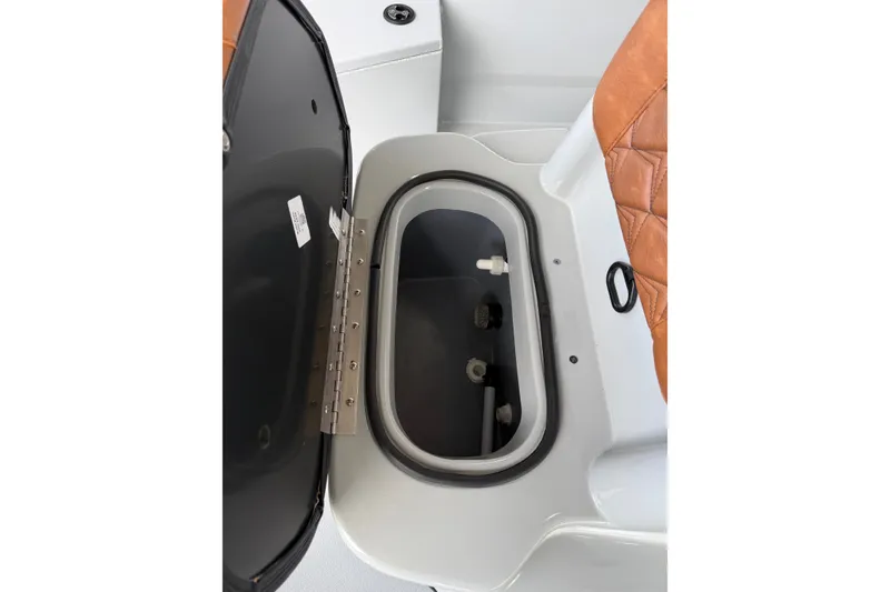 Slide: The Image of Open storage compartment in Avid 207 Recon boat, featuring brown leather seating, 2027 model. - 6