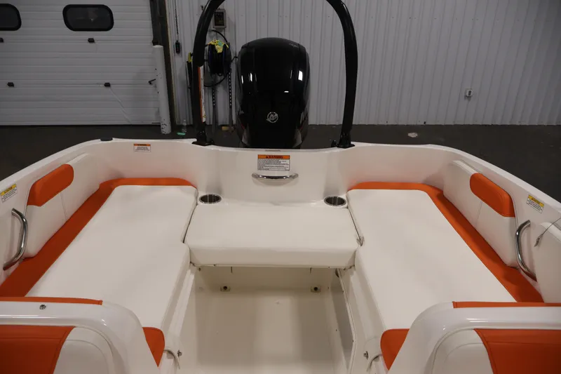 Slide: The Image of 2019 Bayliner Element 180 XL boat interior with orange and white seating, cup holders, and motor. - 29
