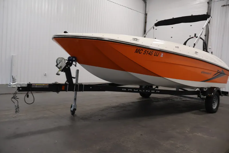 Slide: The Image of 2019 Bayliner Element 180 XL boat with orange hull on trailer in indoor setting. - 38