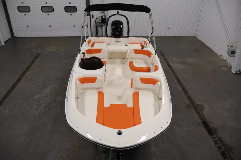Slide: The Image of 2019 Bayliner Element 180 XL boat with orange and white seating in a garage. - 40