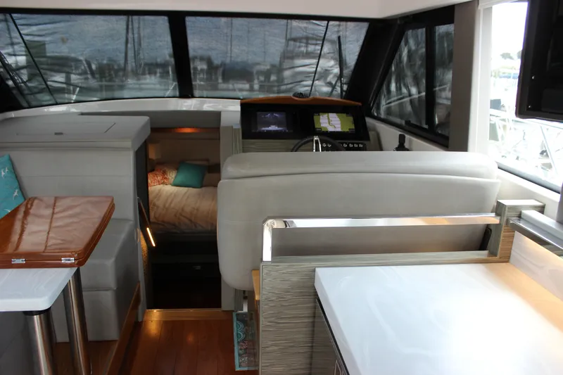 Slide: The Image of 2019 Tiara Yachts C39 Coupe interior with helm, seating, and cabin view. - 60