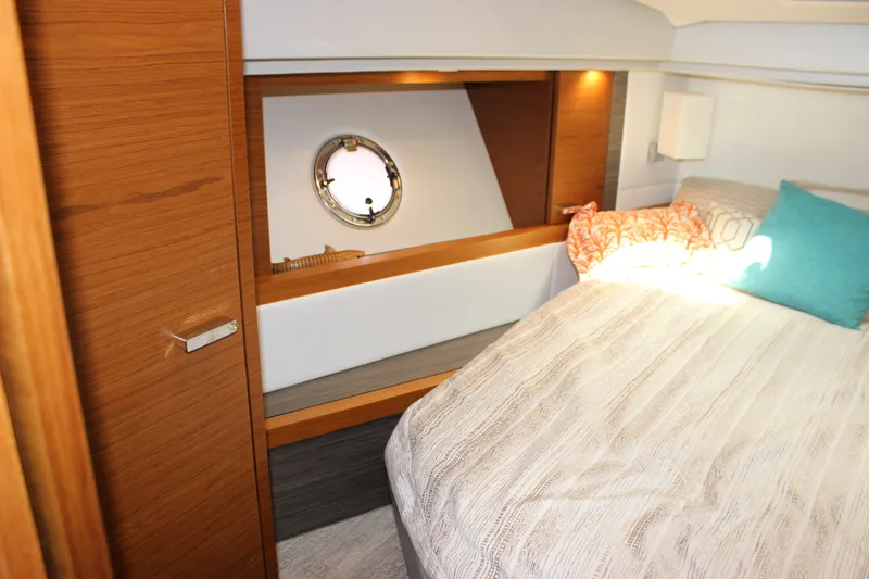 Slide: The Image of 2019 Tiara Yachts C39 Coupe cabin interior with bed, porthole, and wooden accents. - 78