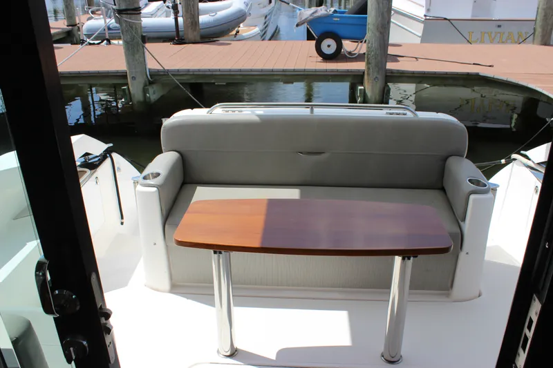 Slide: The Image of 2019 Tiara Yachts C39 Coupe cockpit with seating and wooden table, docked at marina. - 40