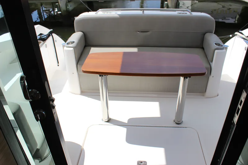 Slide: The Image of 2019 Tiara Yachts C39 Coupe cockpit with cushioned seating and wooden table. - 41