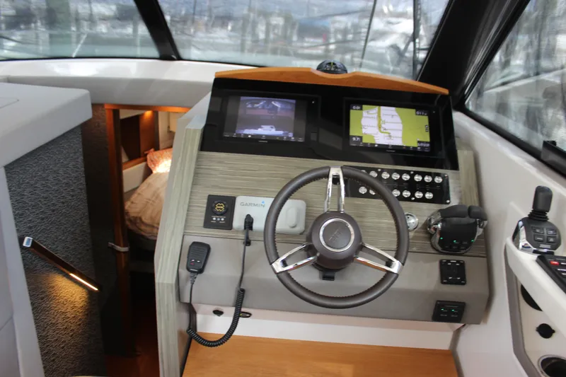 Slide: The Image of 2019 Tiara Yachts C39 Coupe helm with navigation screens and steering wheel. - 70