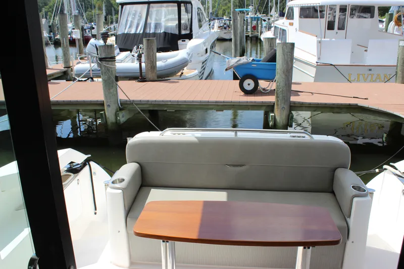 Slide: The Image of 2019 Tiara Yachts C39 Coupe interior with dock view, featuring seating and table. - 42