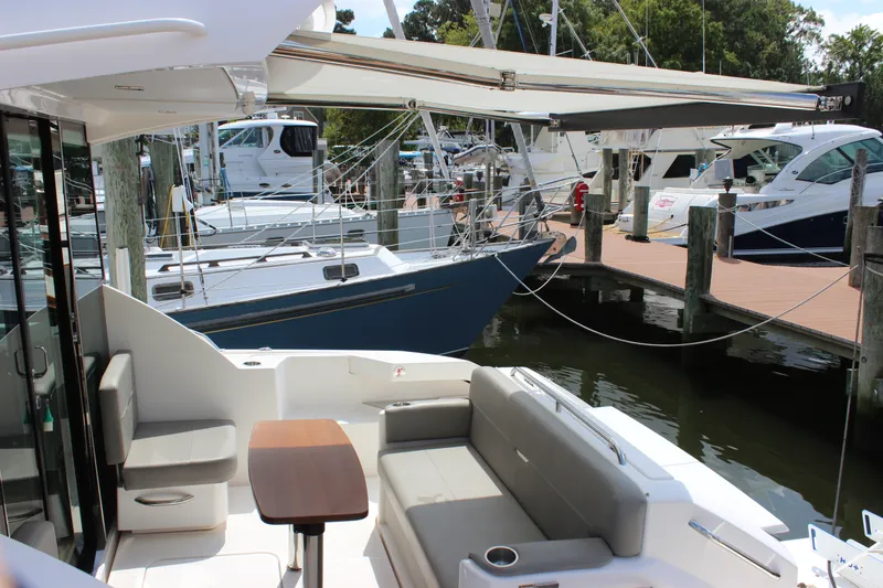 Slide: The Image of 2019 Tiara Yachts C39 Coupe at marina, featuring outdoor seating and retractable awning. - 28
