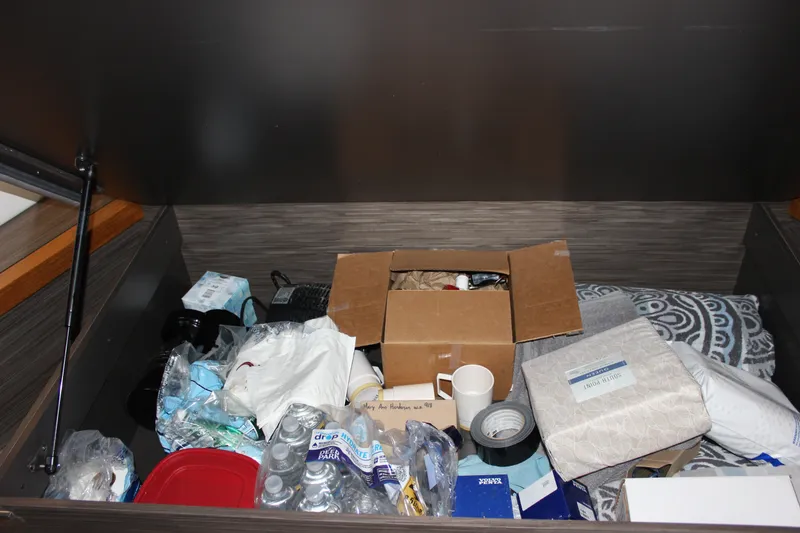 Slide: The Image of Storage compartment in 2019 Tiara Yachts C39 Coupe filled with various supplies and items. - 107