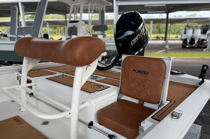 Slide: The Image of 2027 Avid 19 FSX boat interior with brown leather seating and Yamaha engine. - 15