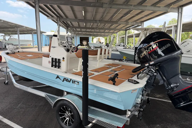 The Image of 2027 Avid 19 FSX boat with Yamaha engine on trailer in covered storage. - 0